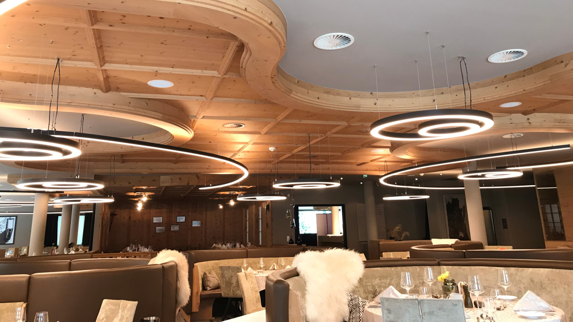 Abgehängte LED-Ringleuchten im Speisesaal des Berglandhotels Sölden