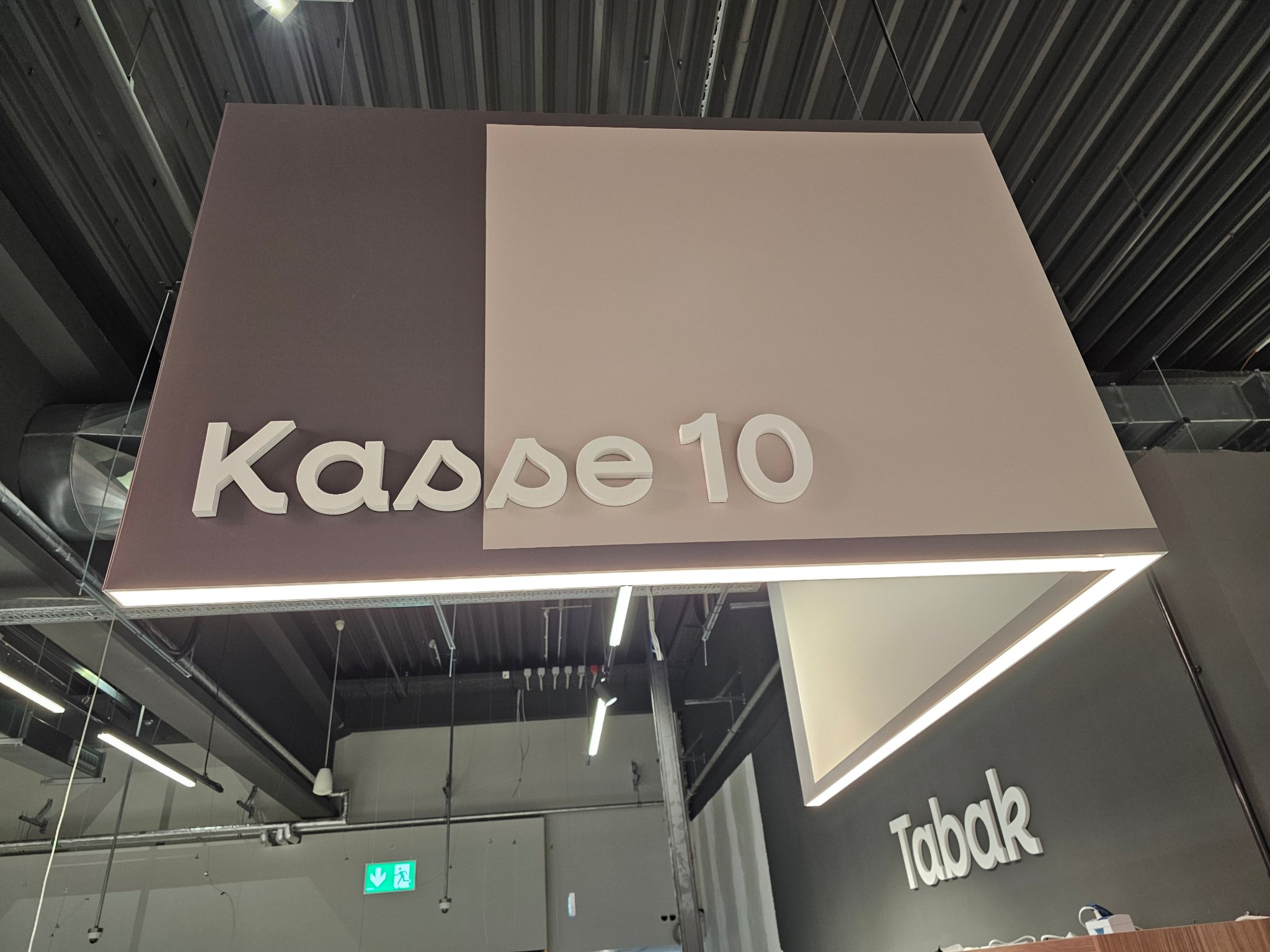 Detailaufnahme des beleuchteten Kassenkubus „Kasse 10“ im Supermarkt Hemer