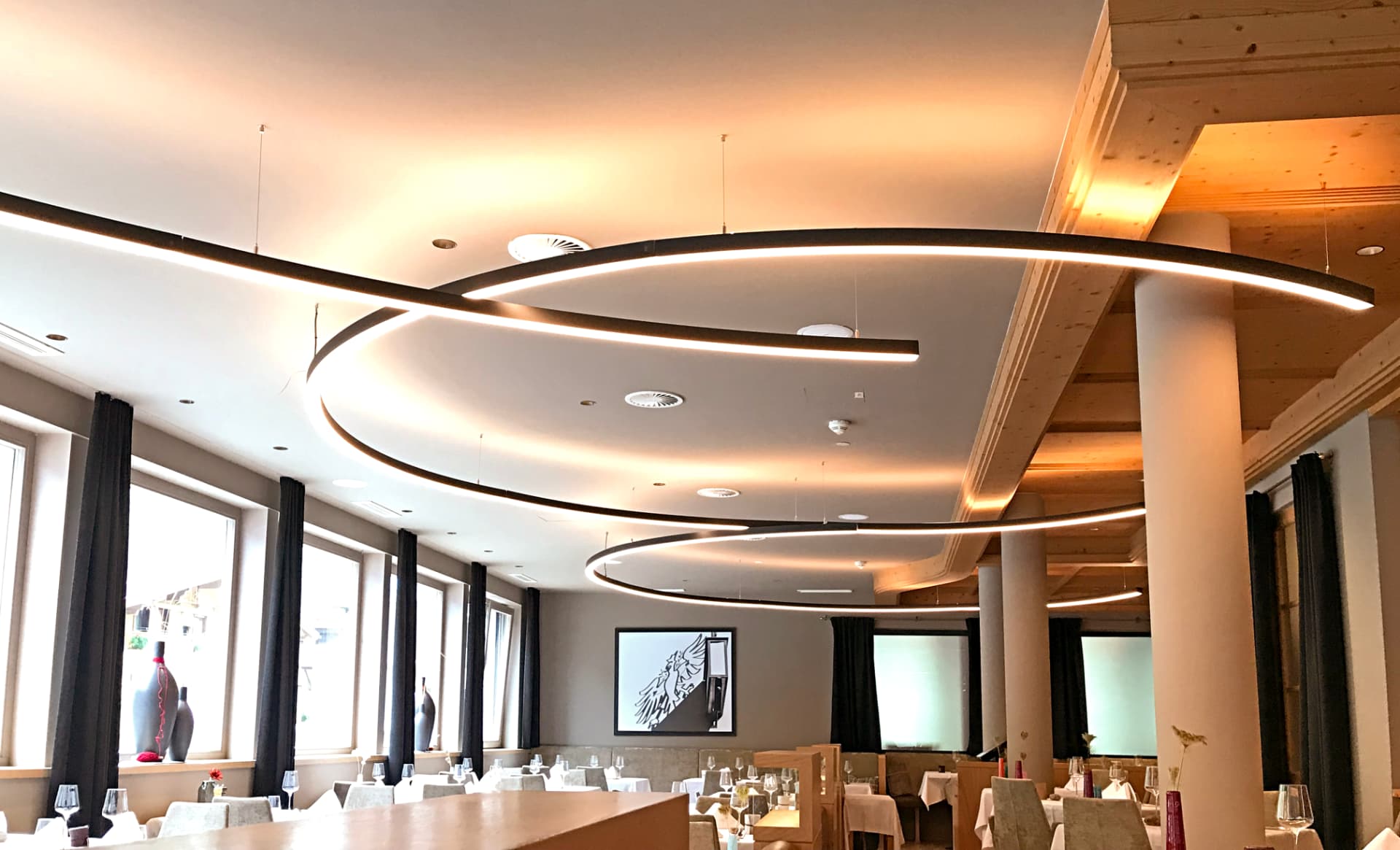 Geschwungene LED-Lichtbänder über dem Restaurantbereich im Berglandhotel Sölden